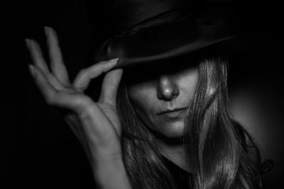 Close-up of woman against black background