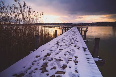 Stormy weather during sunset and snowcapped pier