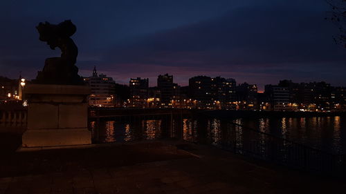 Statue in city at night