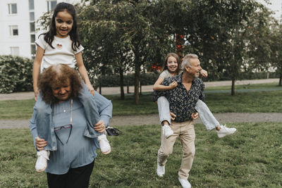 Playful grandparents and grandchildren at park