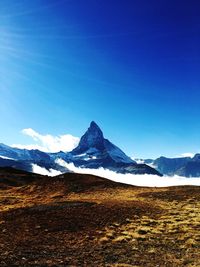 Scenic view of snowcapped mountains against clear blue sky