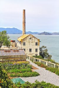 Built structure by sea against sky