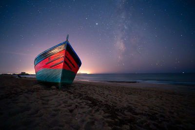 Lifeguard hut on beach against sky at night