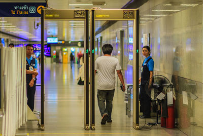 People walking in illuminated corridor