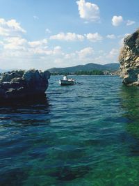 Boats in sea with mountain in background