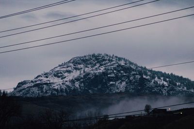 Low angle view of snow covered mountain against sky