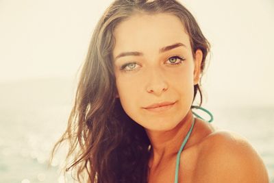 Close-up portrait of beautiful woman against sky