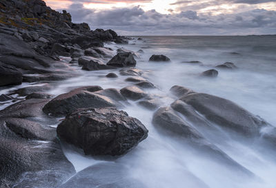 Scenic view of rocks in sea against sky