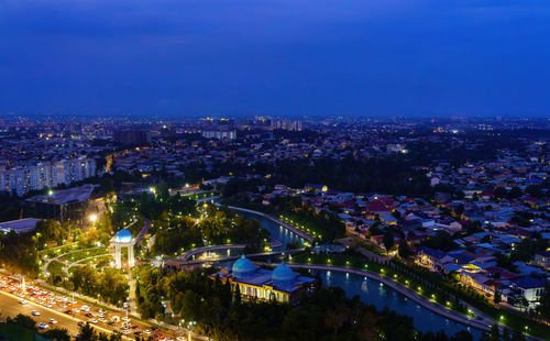 High angle view of illuminated cityscape against clear sky