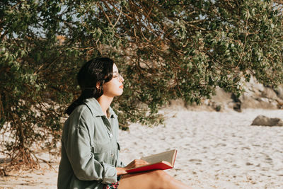 Side view of teenage girl holding book