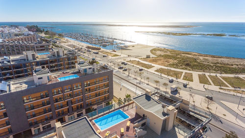 High angle view of buildings by sea against sky