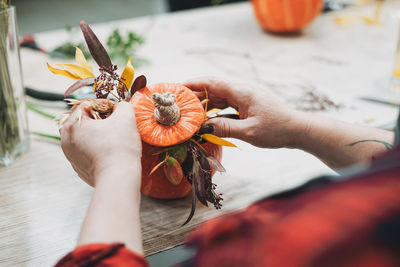 Cropped image of woman decorating pumpkin