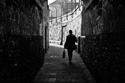 Rear view of woman walking on paved walkway