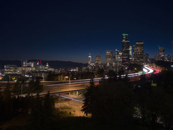 Illuminated buildings against sky at night