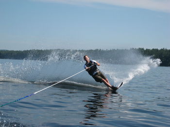 Man surfing in sea against sky