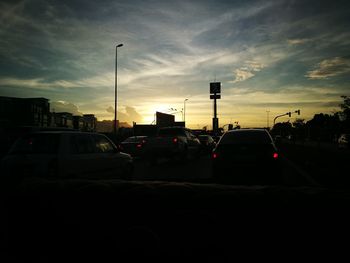 Cars on road in city against sky