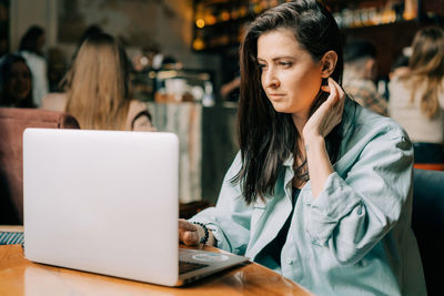 Businesswoman using laptop at table