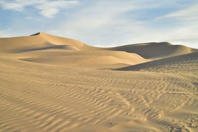 Sand dunes in desert against sky