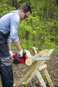 Side view of man working on plant