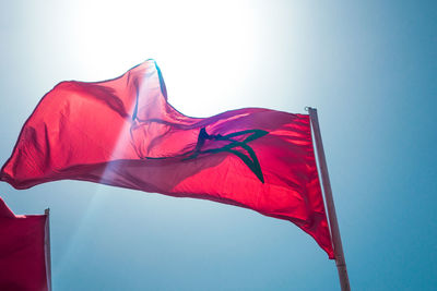 Low angle view of flag against blue sky