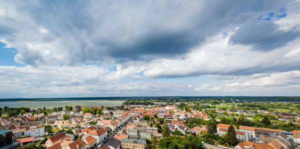 High angle view of townscape by sea against sky