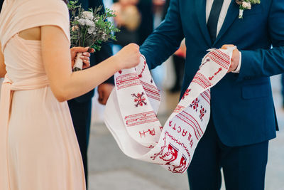 Midsection of couple holding hands