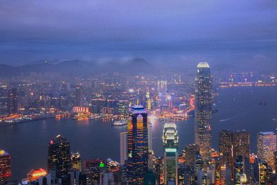 Aerial view of modern illuminated buildings in city at dusk