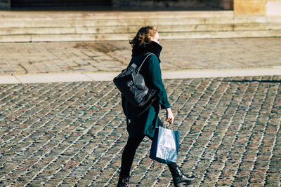 Full length of woman walking on street in city