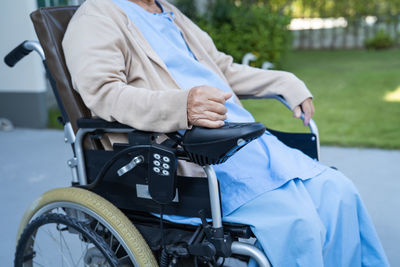 Midsection of man holding wheelchair