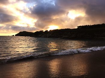 Scenic view of beach against sky during sunset