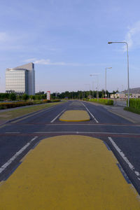 Empty road in city against sky