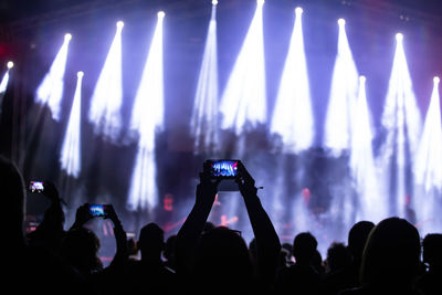Group of people photographing at music concert