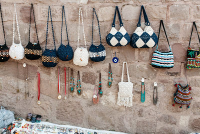 Tote bags and necklaces hanging on wall at market