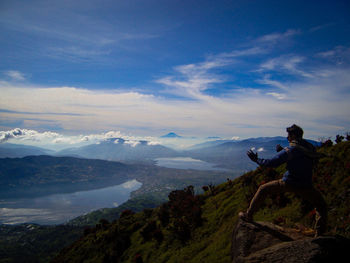 Man looking at mountain against sky