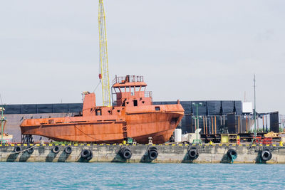 Cranes at commercial dock against sky