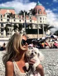 Woman holding dog at beach