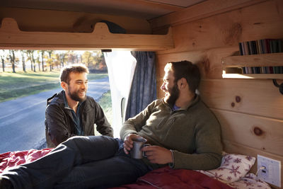 Man talking to friend relaxing in camper van