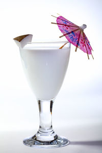 Close-up of drink on table against white background