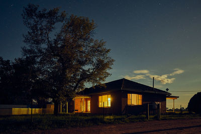 House on field against sky at night