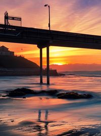 Scenic view of bridge over river during sunset