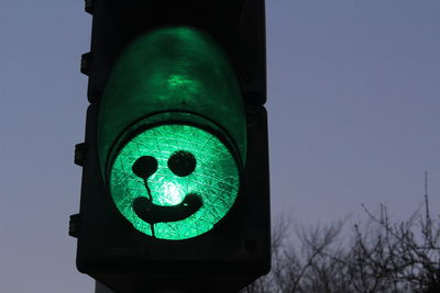 High section of illuminated street traffic light  against blue sky