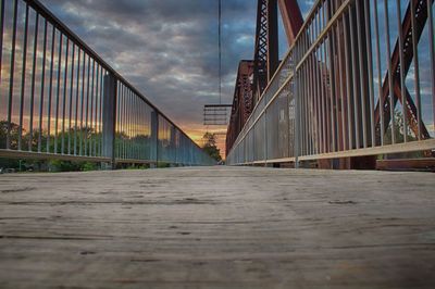 Footbridge in city against sky