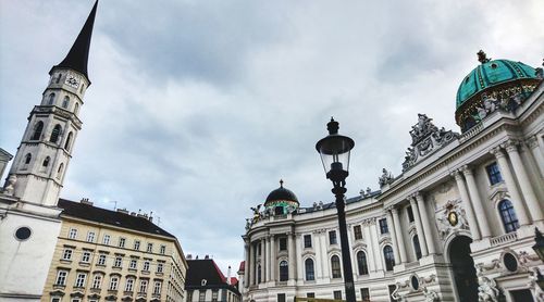 Low angle view of buildings against cloudy sky