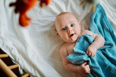 High angle view of baby lying in crib