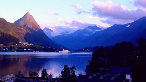 Scenic view of lake by mountains against sky