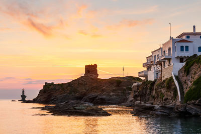 Castle and lighthouse in chora of andros island early in the morning.