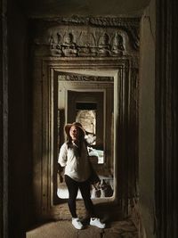 Full length of woman standing at entrance of building