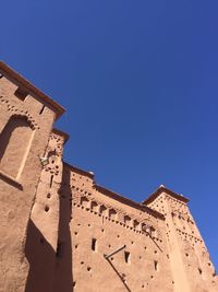 Low angle view of old building against blue sky