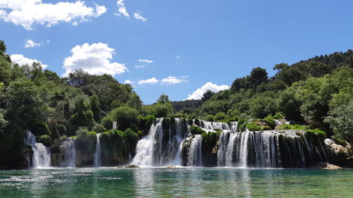 Scenic view of waterfall against sky