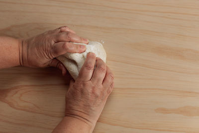High angle view of hand holding bread on table